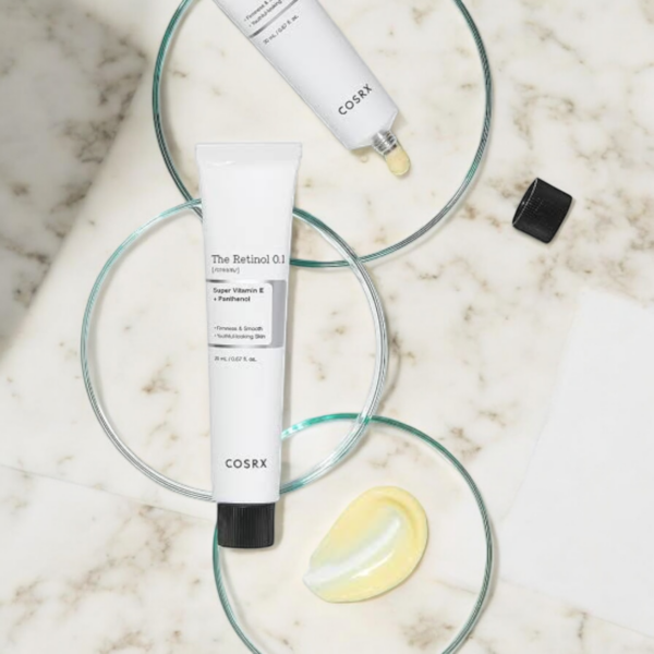 COSRX The Retinol 0.1 Cream avec sa texture crémeuse appliquée à côté du tube, montrant la consistance du produit.